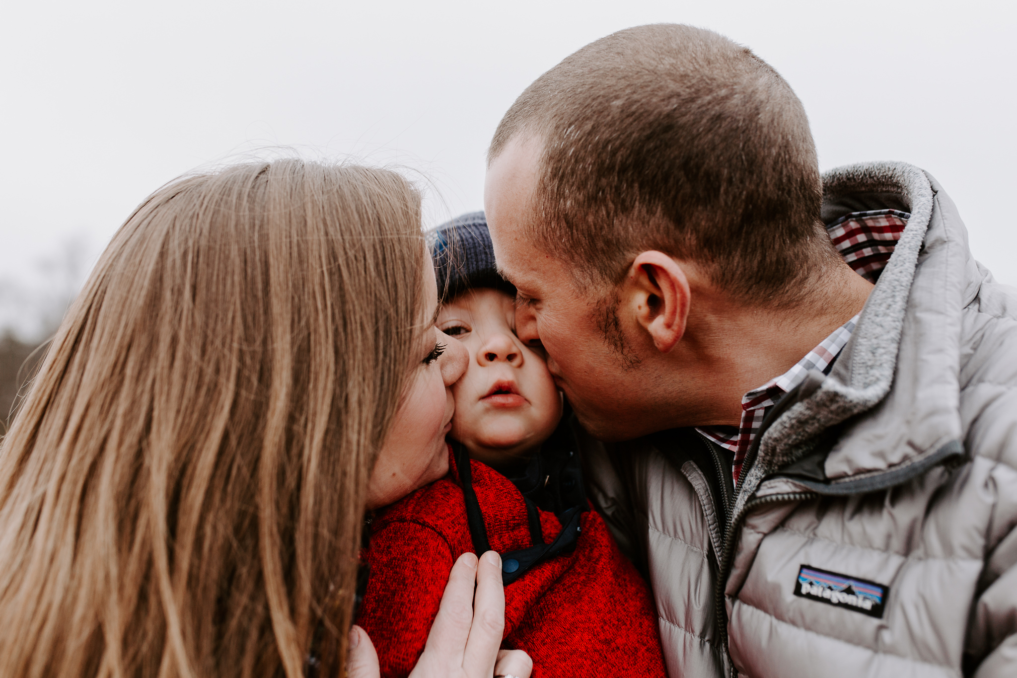 Young family lifestyle photo in a dried grass field with snow